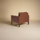 Cyrene W contemporary faux leather single seater sofa with wooden legs in warm tan upholstery back three quarter isometric view