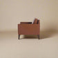 Cyrene W contemporary faux leather single seater sofa with wooden legs in warm tan upholstery side view