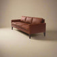 Cyrene W contemporary faux leather three seater sofa with wooden legs in warm tan upholstery isometric view