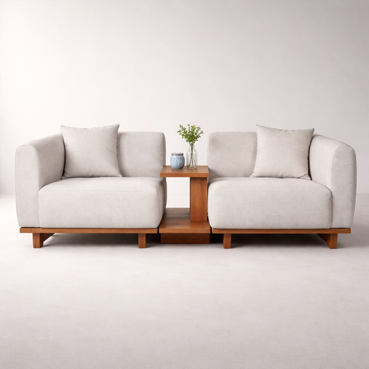 Modern white sofa with wooden legs and a small table in the center on a plain background